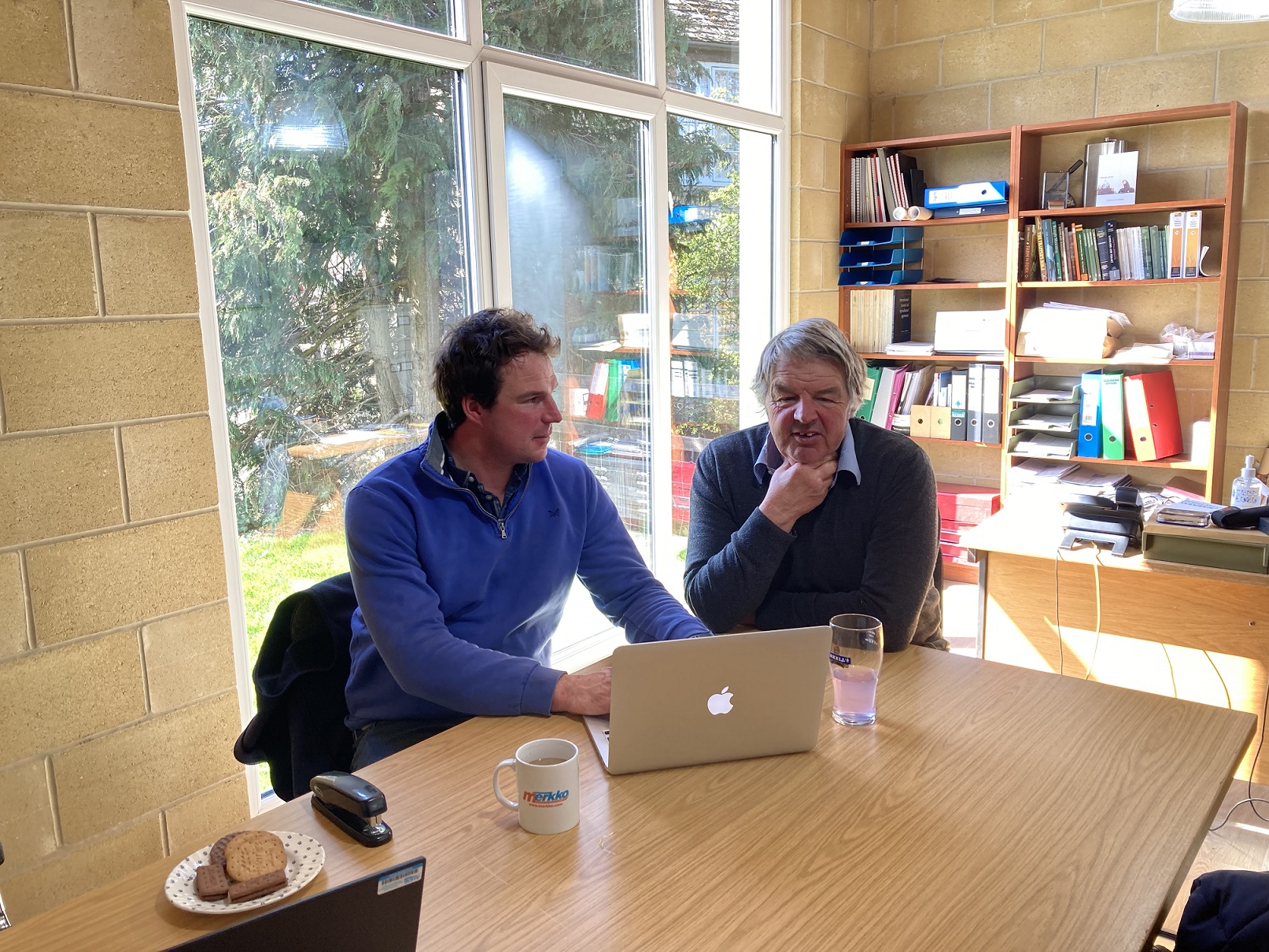 Two men - Giles and Tim Blanchard - sat in office working on laptop